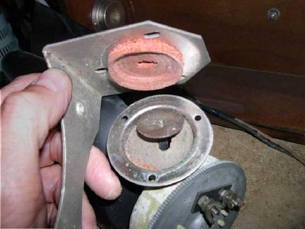 Two foam pads surround a metal speaker mounting disc.